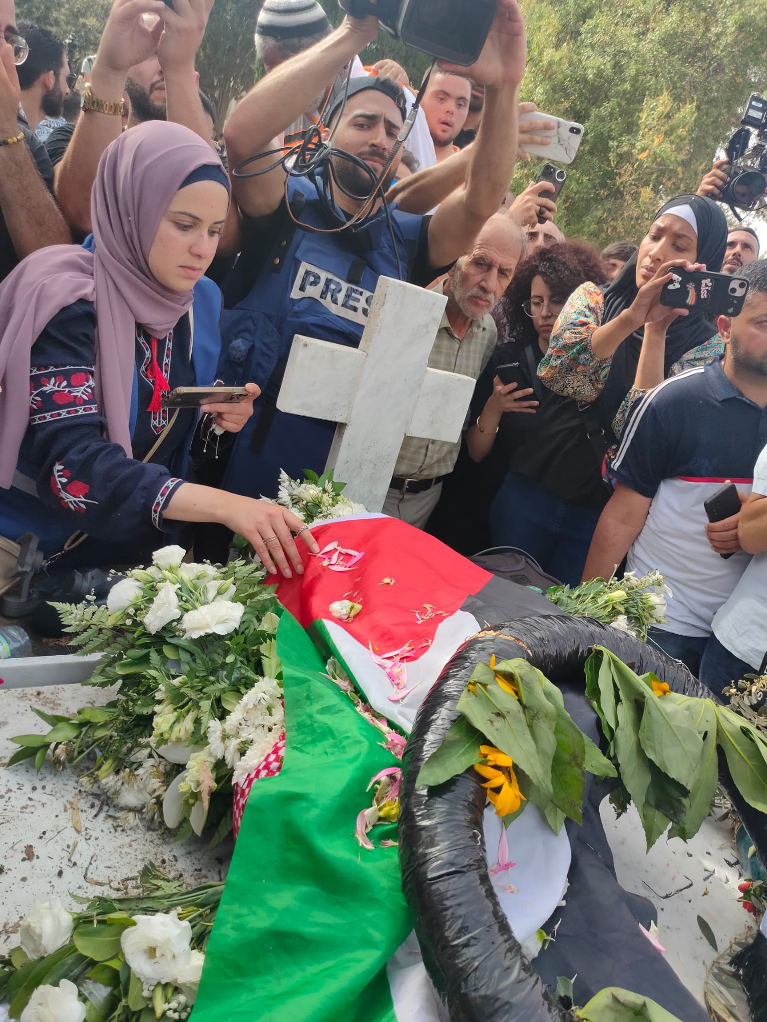 وضع الورود على قبر شيرين ابو عاقلة بعد دفنها